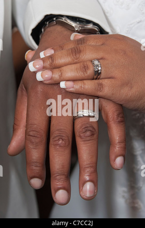 Kirchliche afroamerikanische Hochzeitszeremonie Paare mit Braut zeigen ihre Hände mit Eheringen in den USA vertikale Hi-res Stockfoto