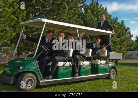 Amerikanischer Bräutigam und Trauzeugen, die nach der Zeremonie in Ohio, USA, Spaß auf einem großen Golfwagen haben, der nach der Zeremonie im US-amerikanischen Lifestyle Daily Life horizontal Hi-res steht Stockfoto