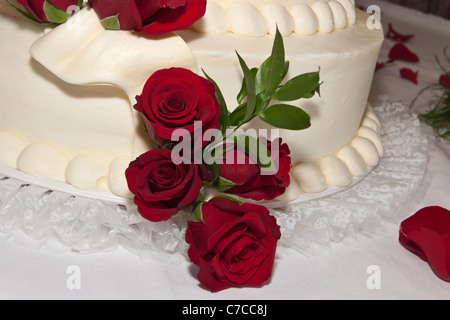 Amerikanisch traditionell ein weißer Hochzeitstorte, dekoriert mit roten Rosen in den USA Hi-res Stockfoto