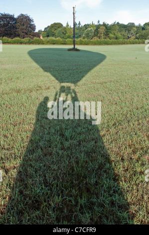 Schatten der Heißluftballon auf Feld, Menschen, die im Warenkorb sichtbar. Stockfoto