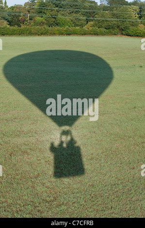 Schatten der Heißluftballon auf Feld, Menschen, die im Warenkorb sichtbar. Stockfoto