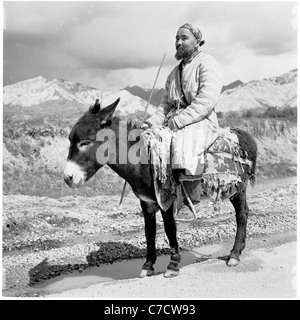 1950er Jahre, historisch, ein einheimischer Stammesmann sitzt auf seinem Esel auf einem Schotterweg im Ural, Eurasien, Russland, einer Grenze zwischen Europa und Asien. Stockfoto