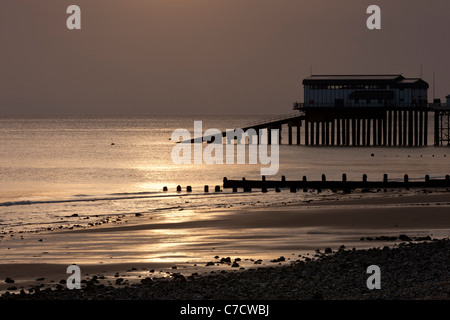 Cromer Strand bei Sonnenaufgang im Sommer mit der Rettungsstation am Pier in Norfolk, England Stockfoto