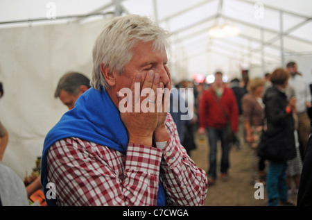 Der Mann hält sein Gesicht vor Schmerzen, nachdem er beim Fiery Food Festival in Brighton, Großbritannien, ein scharfes Chili gegessen hat Stockfoto