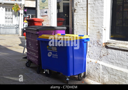 Große fahrbare Behälter für Gewerbeabfälle in einer Gasse abseits nur die High Street, Winchester, Hampshire, England Stockfoto