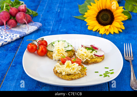 Kartoffeln aus dem Ofen, serviert mit Tete de Moine Käse und garniert mit Tomaten, Gurken und Radieschen Stockfoto