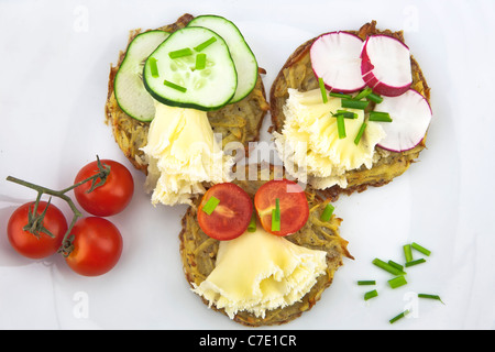 Kartoffeln aus dem Ofen, serviert mit Tete de Moine Käse und garniert mit Tomaten, Gurken und Radieschen Stockfoto