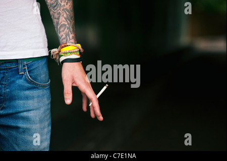 Tätowierte Teenager halten eine Cannabis-Joint Stockfoto