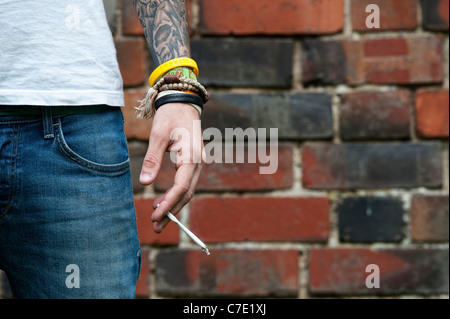 Tätowierte Teenager halten eine Cannabis-Joint Stockfoto