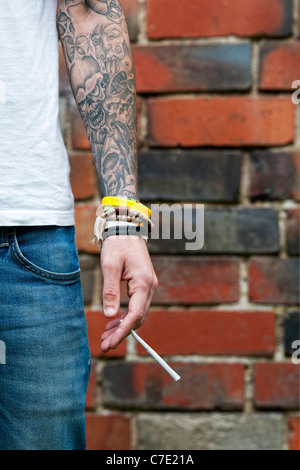 Tätowierte Teenager halten eine Cannabis-Joint Stockfoto