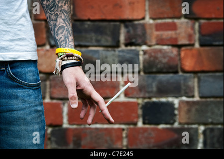 Tätowierte Teenager halten eine Cannabis-Joint Stockfoto