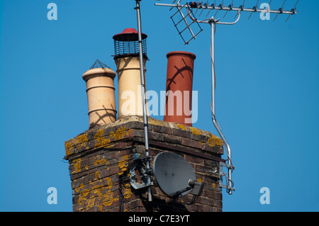 Schornstein mit TV-Antenne und Satellitenschüssel Stockfoto