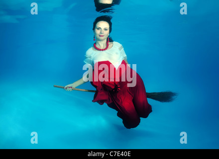 Eine junge Frau mit großen Haar posiert in einem Pool unter Wasser Stockfoto