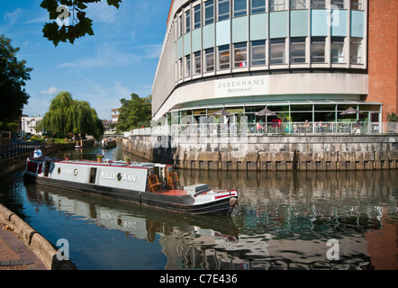 Eine schmale Kanalboot vorbei Debenhams Department Store Restaurant mit Blick auf den Fluss Wey Guildford Surrey England uk Stockfoto