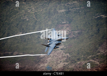 USAF F-15E Strike Eagle macht eine Drehung bei einem niedrig fliegenden Flug in mid Wales erschossen von der Bergseite Stockfoto