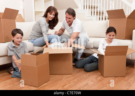 Familie, Eltern, Sohn und Tochter, Kisten auspacken und der Umzug in ein neues Zuhause. Stockfoto
