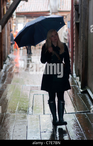 Norwegische Frau zu Fuß für die Straßen von Bergen unter dem Regen des Herbstes. Stockfoto