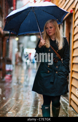 Norwegische Frau zu Fuß für die Straßen von Bergen unter dem Regen des Herbstes. Stockfoto