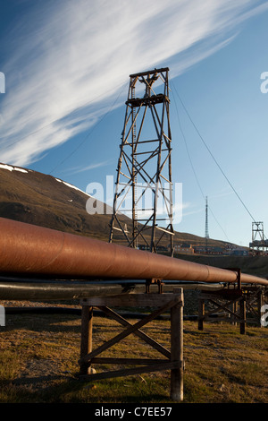 Thermische Heizungsrohre in Longyearbyen, Svalbard. Alte Kohle-Bergbau-Maschinen im Hintergrund Stockfoto