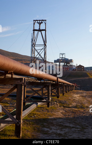 Thermische Heizungsrohre in Longyearbyen, Svalbard. Alte Kohle-Bergbau-Maschinen im Hintergrund Stockfoto