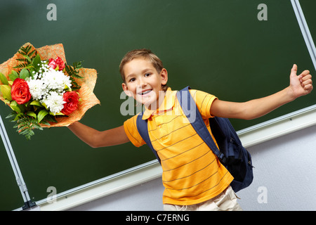 Porträt von smart Schulkind mit Blumenstrauß von der Tafel Stockfoto