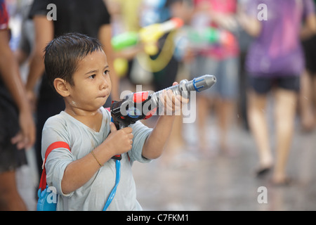 Thai Kind feiert Song Kran buddhistischen Neujahrsfest in der Silom Road, Bangkok, Thailand Stockfoto