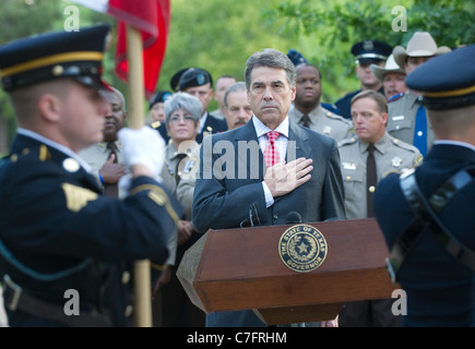 Texas-Gouverneur Rick Perry und andere Gäste begrüssen die amerikanische Flagge mit Händen über Herzen an einer Gedenkfeier für 9/11 Angriffe Stockfoto