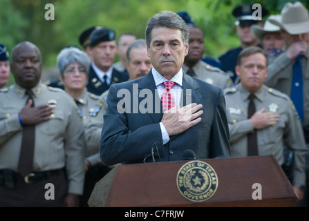 Texas-Gouverneur Rick Perry und andere Gäste begrüssen die amerikanische Flagge mit Händen über Herzen an einer Gedenkfeier für 9/11 Angriffe Stockfoto