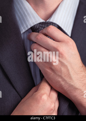 Geschäftsmann, seine Krawatte anpassen. Nahaufnahme der Hände. Stockfoto