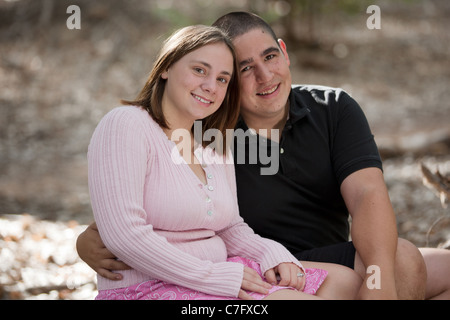 Porträt von eine junge, glücklich verheiratete Paar im Freien in einem Park, lächelnd in die Kamera. Stockfoto