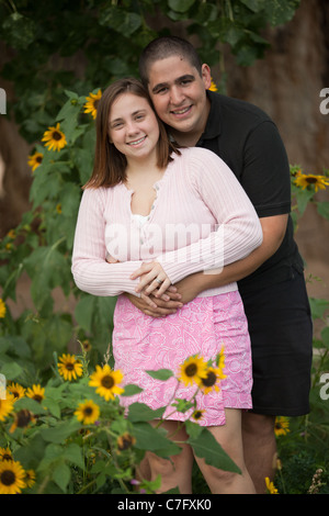 Porträt des jungen Brautpaares draußen im Feld von Blumen Stockfoto