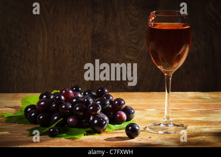Rote Trauben mit Glas Wein Stockfoto
