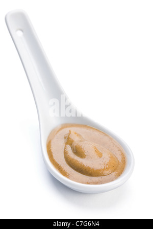 Gelbe Senfsauce in Keramik Löffel auf weiß Stockfoto