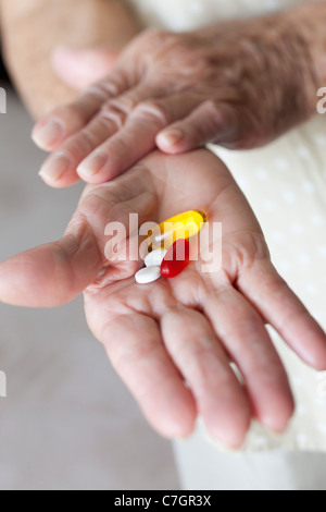 Detail der Kapseln und Tabletten in den Händen einer älteren Frau Stockfoto