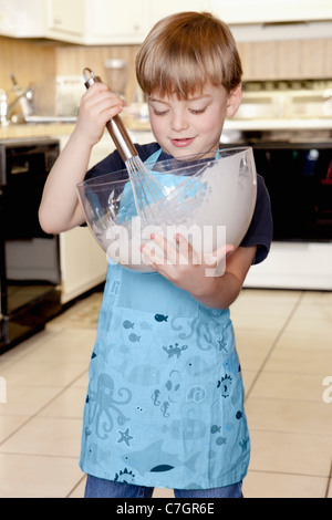 Ein Junge, die Zutaten in einer Schüssel mischen Stockfoto