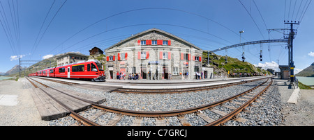 Zug der Rhätische Bahn Ankunft am Bahnhof Ospizio Bernina auf dem Berninapass. Schweiz. Stockfoto