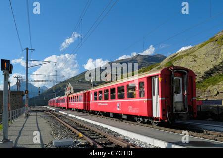Zug der Rhätische Bahn am Bahnhof Ospizio Bernina auf dem Berninapass. Schweiz, Westeuropa, Graubünden, Bernina. Stockfoto