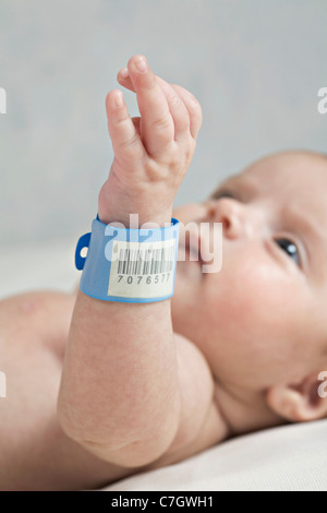 Ein Baby mit einem Krankenhaus ID Armband am Handgelenk, Handgelenk im Fokus Stockfoto