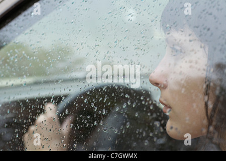 Eine Frau-Fahrer im Auto suchen Fenster, Regentropfen am Fenster sitzen Stockfoto