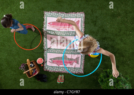 Eine Mutter und Tochter mit Hula Hoops bei einem Picknick im Park, Draufsicht Stockfoto