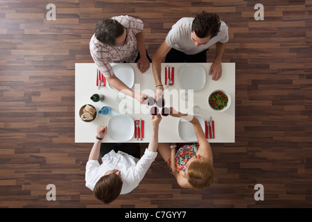 Vier Freunde, die bei einer Dinnerparty, Draufsicht Toasten Stockfoto