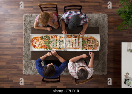 Vier Freunde, die immer bereit sind, zwei große Pizzen, Draufsicht Essen Stockfoto