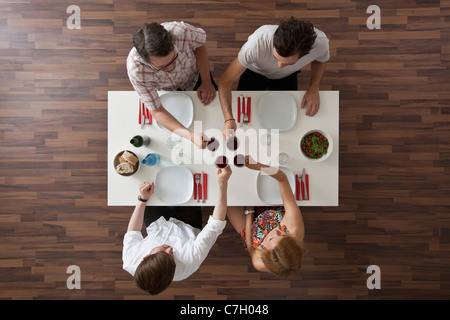 Vier Freunde, die bei einer Dinnerparty, Draufsicht Toasten Stockfoto