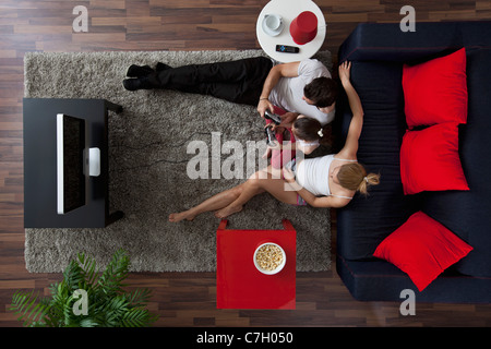 Eine Familie von drei mit Videospielen in ihrem Wohnzimmer, Draufsicht Stockfoto