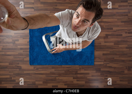 Ein Mann verändert eine Glühbirne, Draufsicht Stockfoto