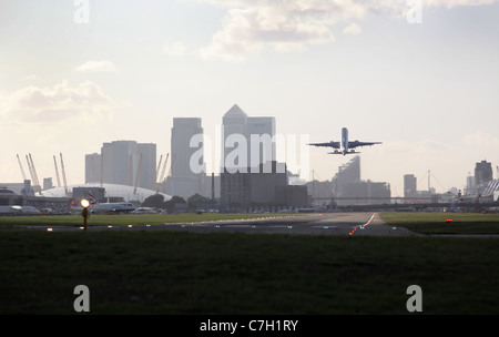 Passagierflugzeuge abheben vom London City Airport mit Docklands City of London und die O2-Arena im Hintergrund Stockfoto
