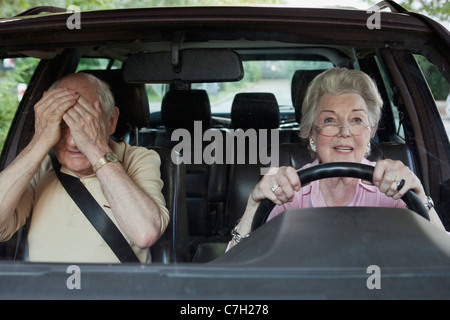 Frau hat Probleme beim fahren, während Man in Beifahrer Sitz verzweifelt Stockfoto