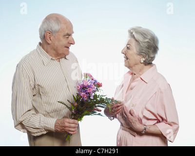 Senior woman gibt senior Frau Blumen Stockfoto