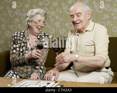 Älteres paar trinken Rotwein machen einen Toast auf der couch Stockfoto