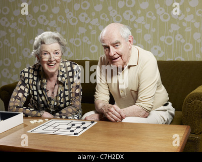 Ältere Mann und Frau spielen Muehles auf couch Stockfoto